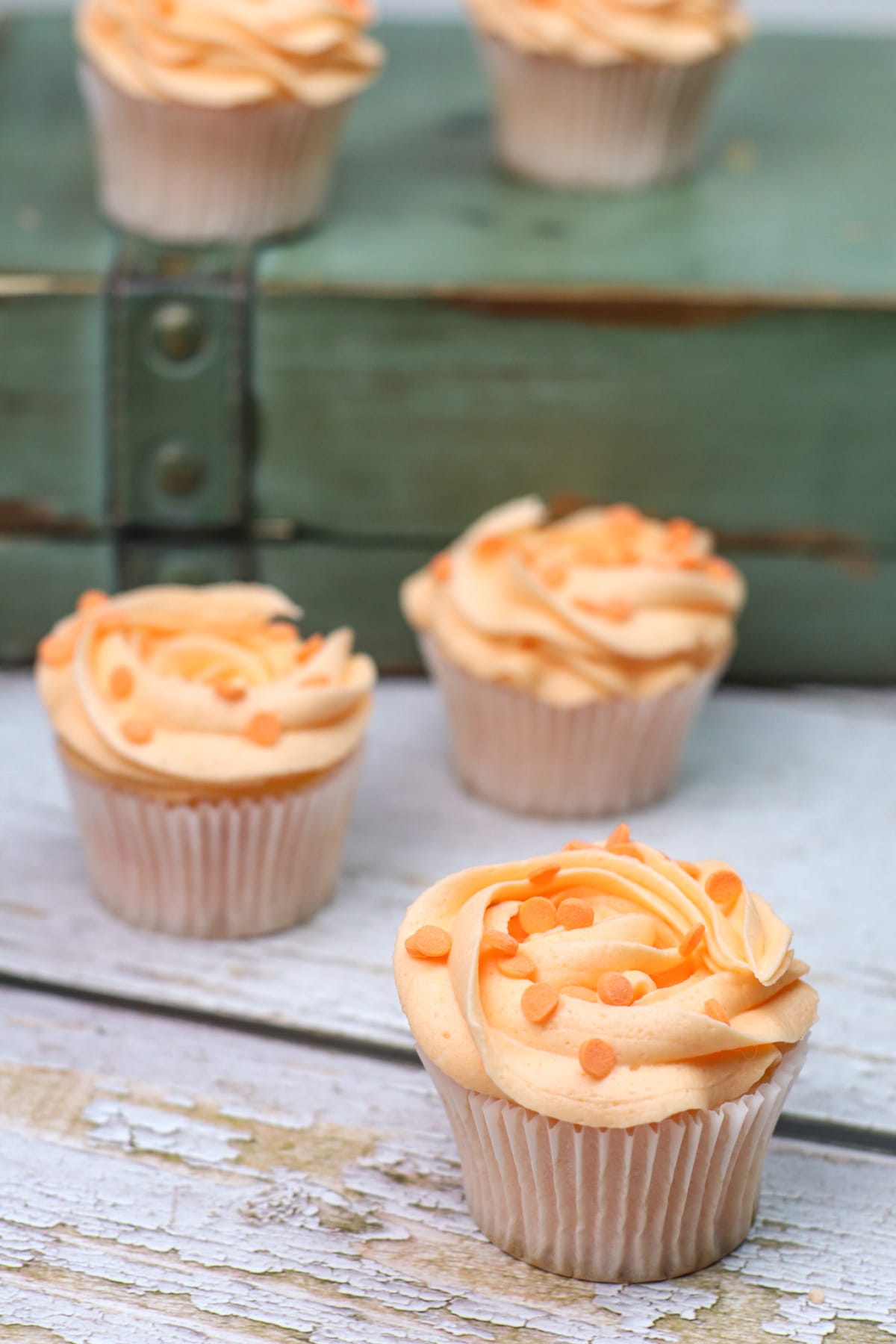 Peach cupcakes with green wooden book in background
