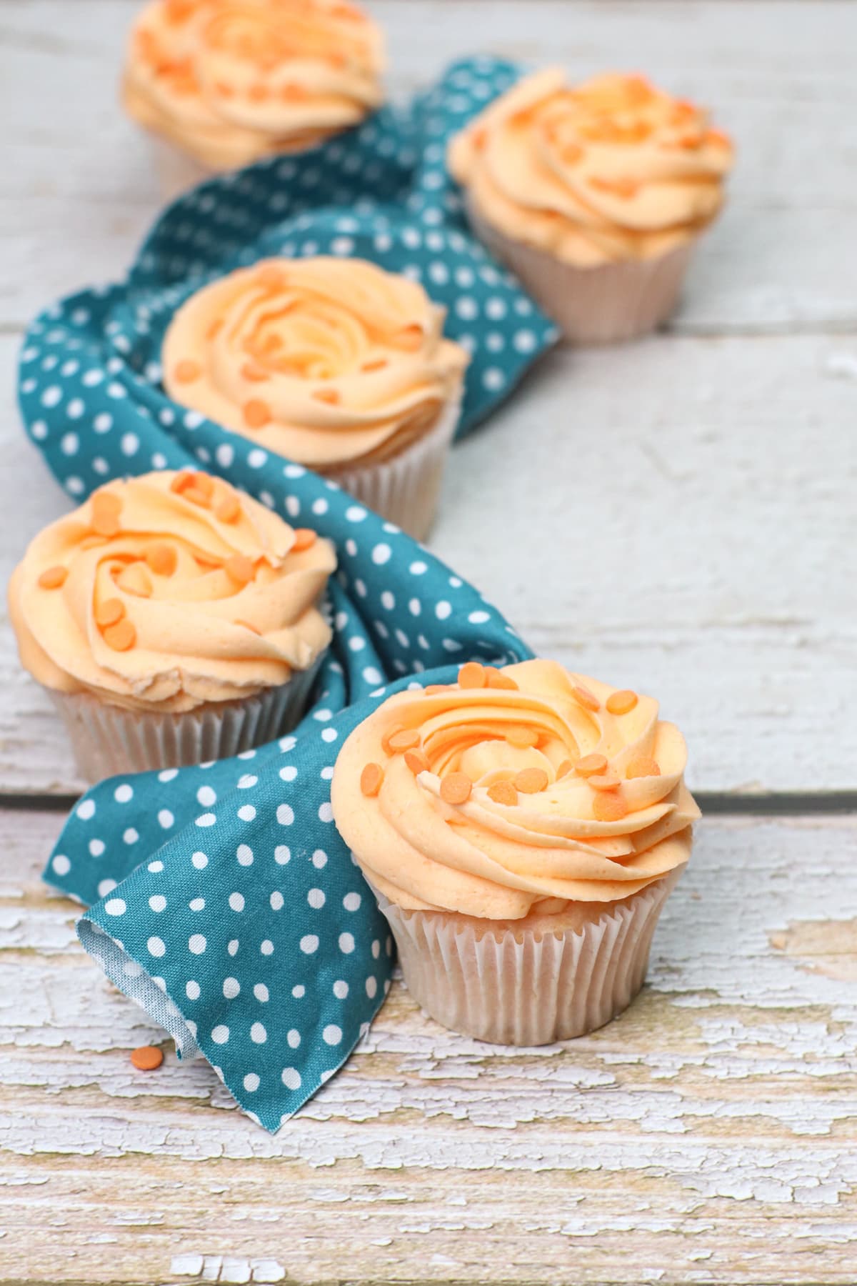 Peach cupcakes with blue napkin