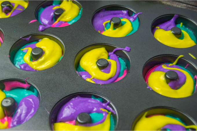 Different colored donut batter in donut tin