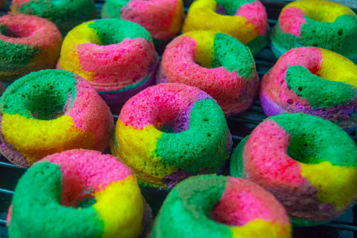 Rainbow donuts cooling on rack