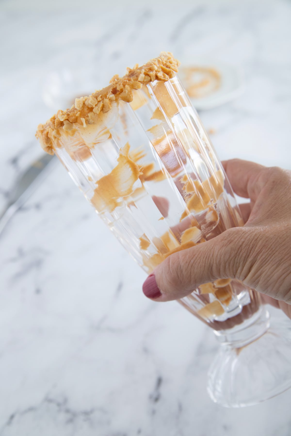 Milkshake glass rimmed with crushed peanut butter