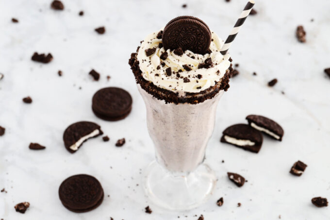 Oreo milkshake with whipped cream and cookie with straw