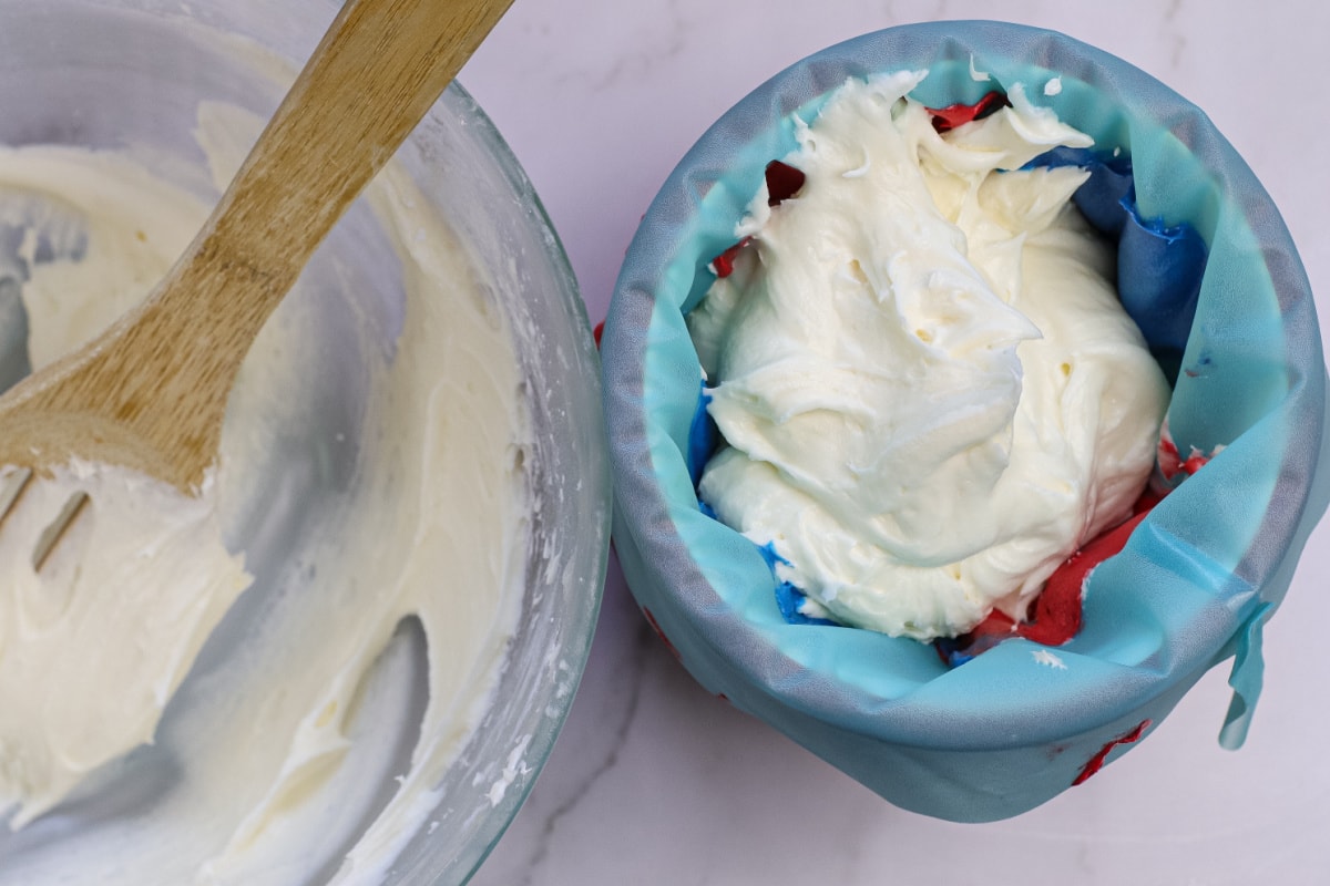 White frosting added to pastry bag with red and blue frosting