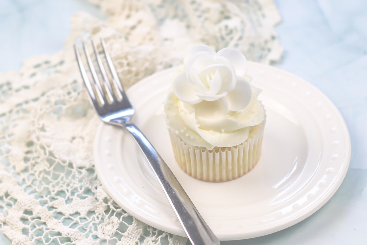 White cupcake on plate with fork