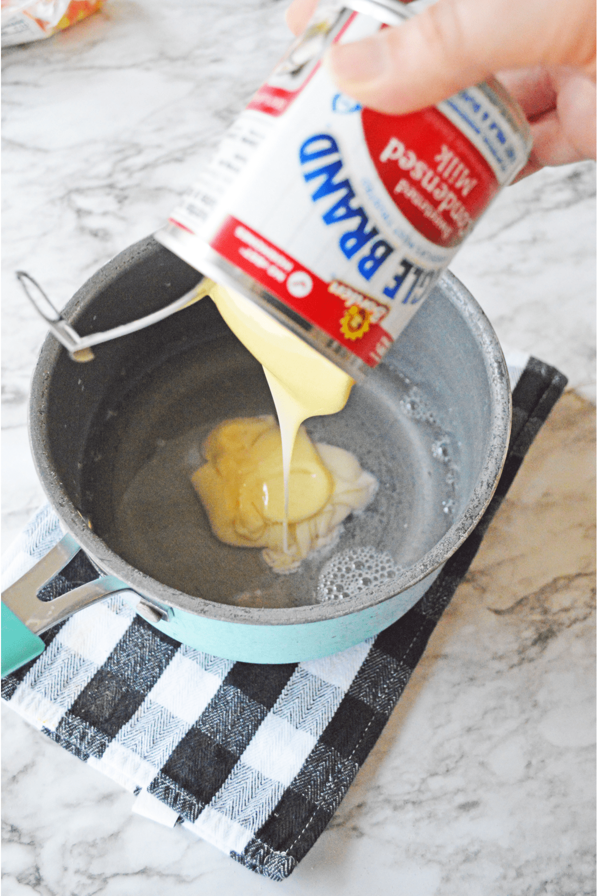 Adding sweetened condensed milk to saucepan