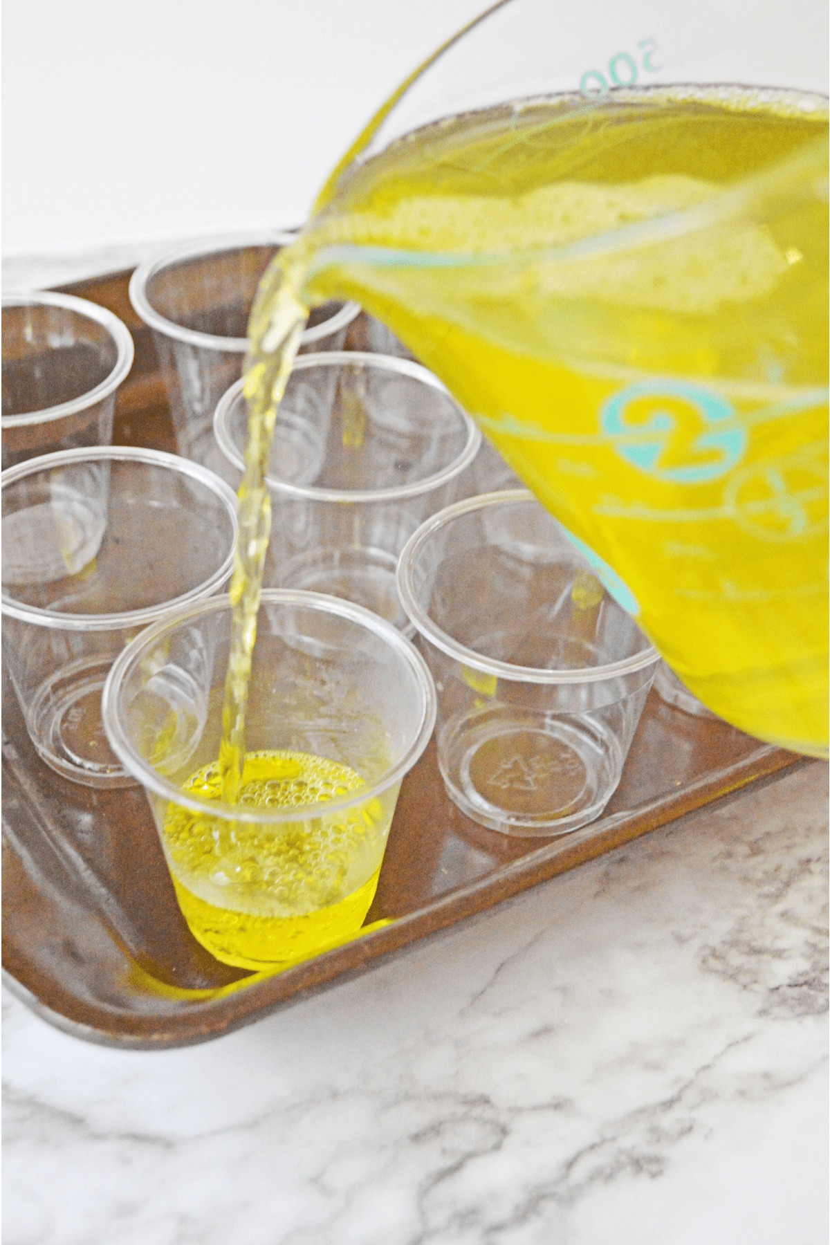 Lemon jello mixture poured into plastic shot cups