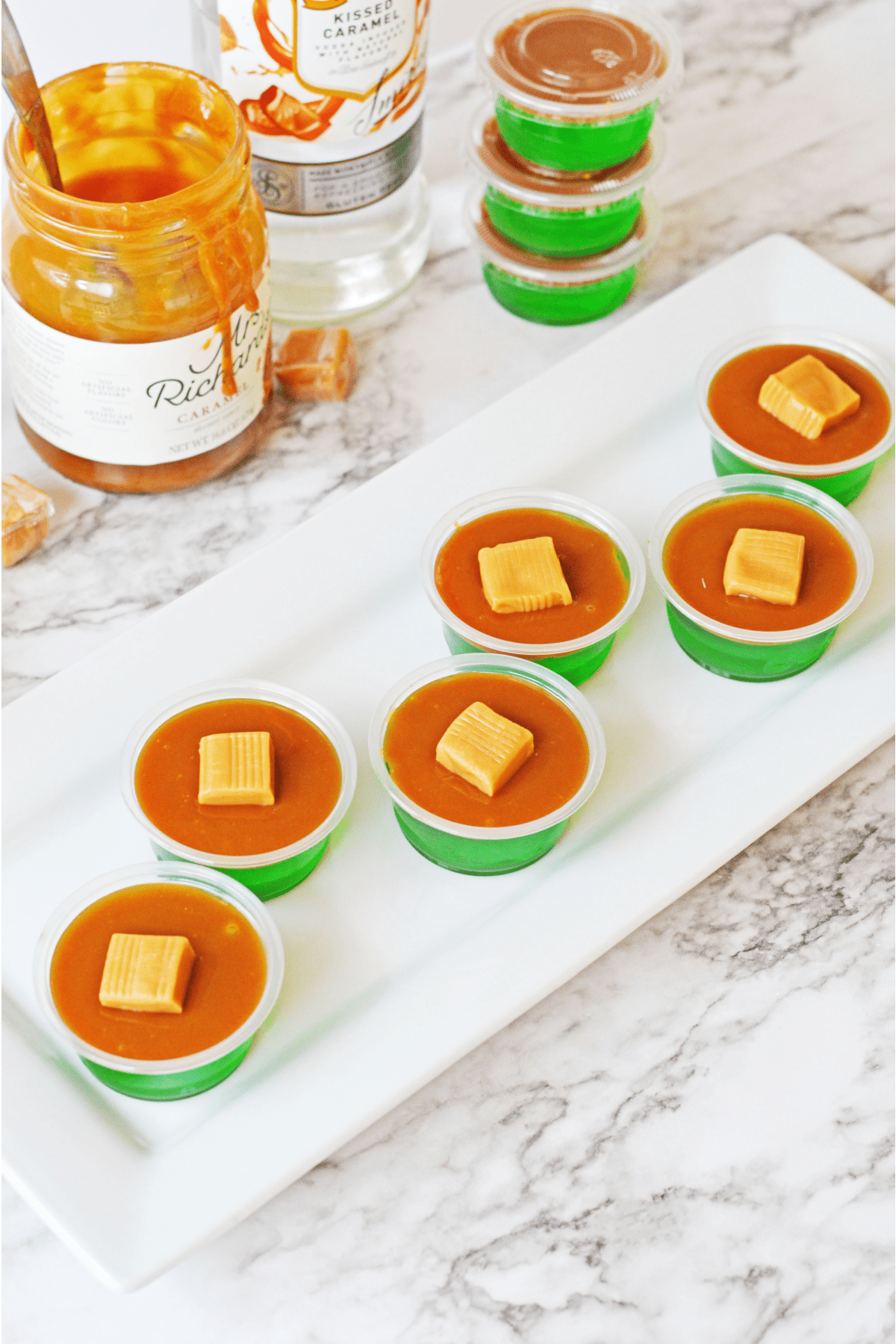 Caramel apple jello shots lined up on white plate