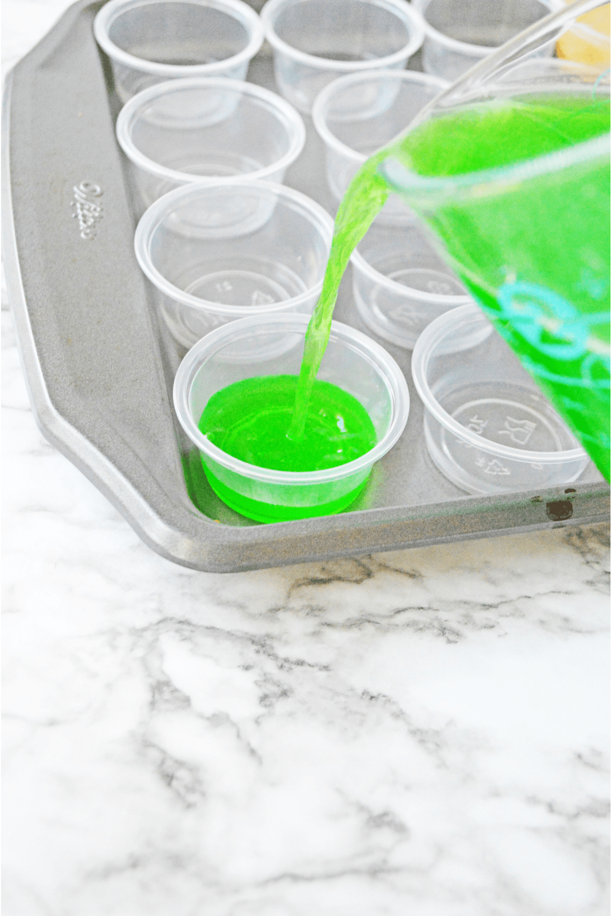 Pouring jello mixture into plastic cups