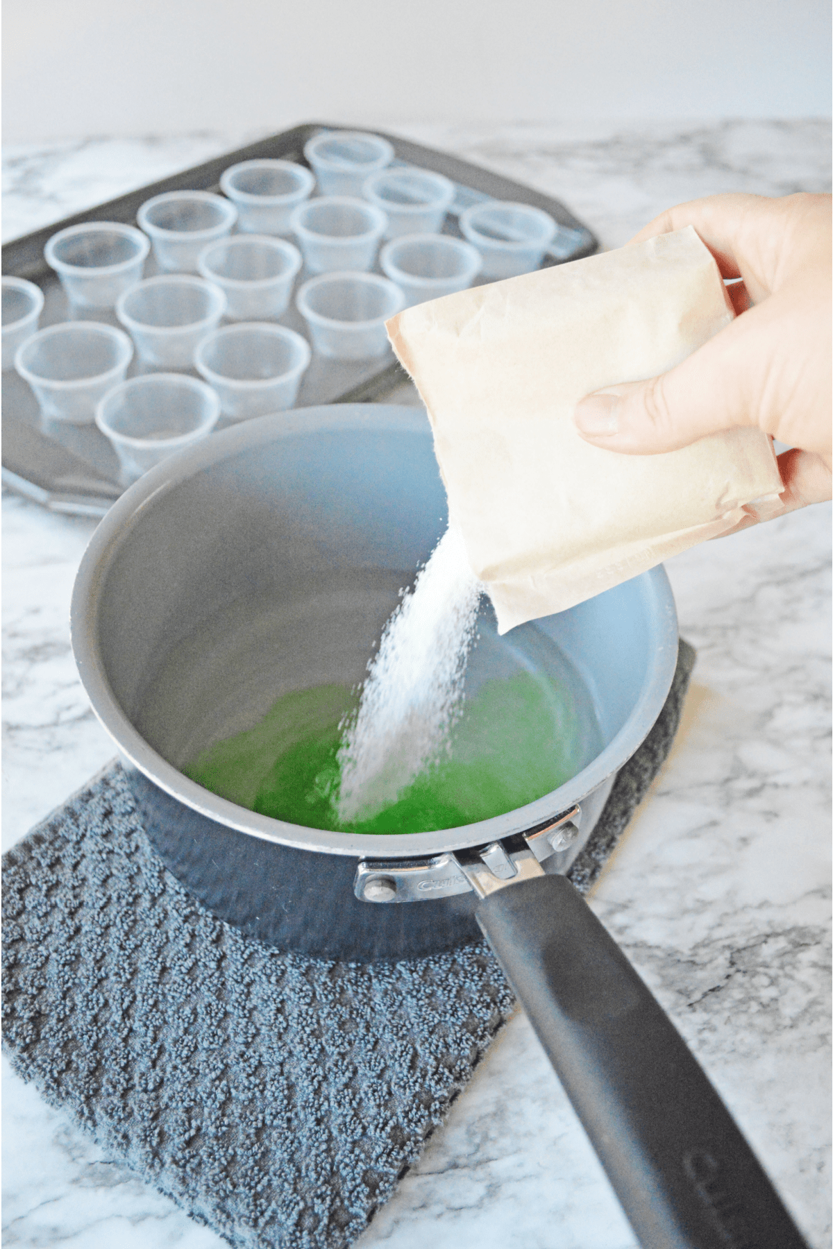 Pouring green apple jello into hot water