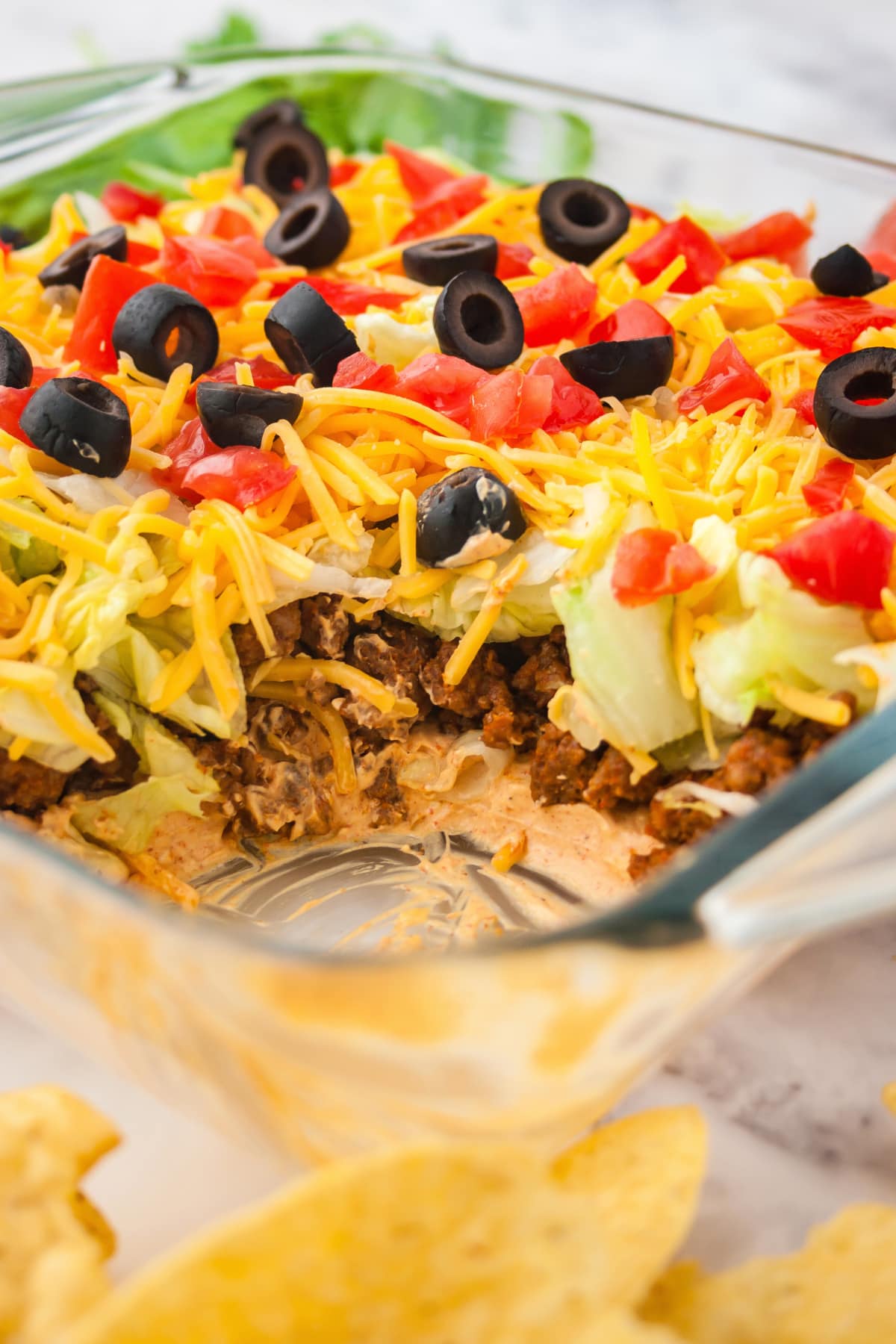 Taco dip with ground beef in glass pan