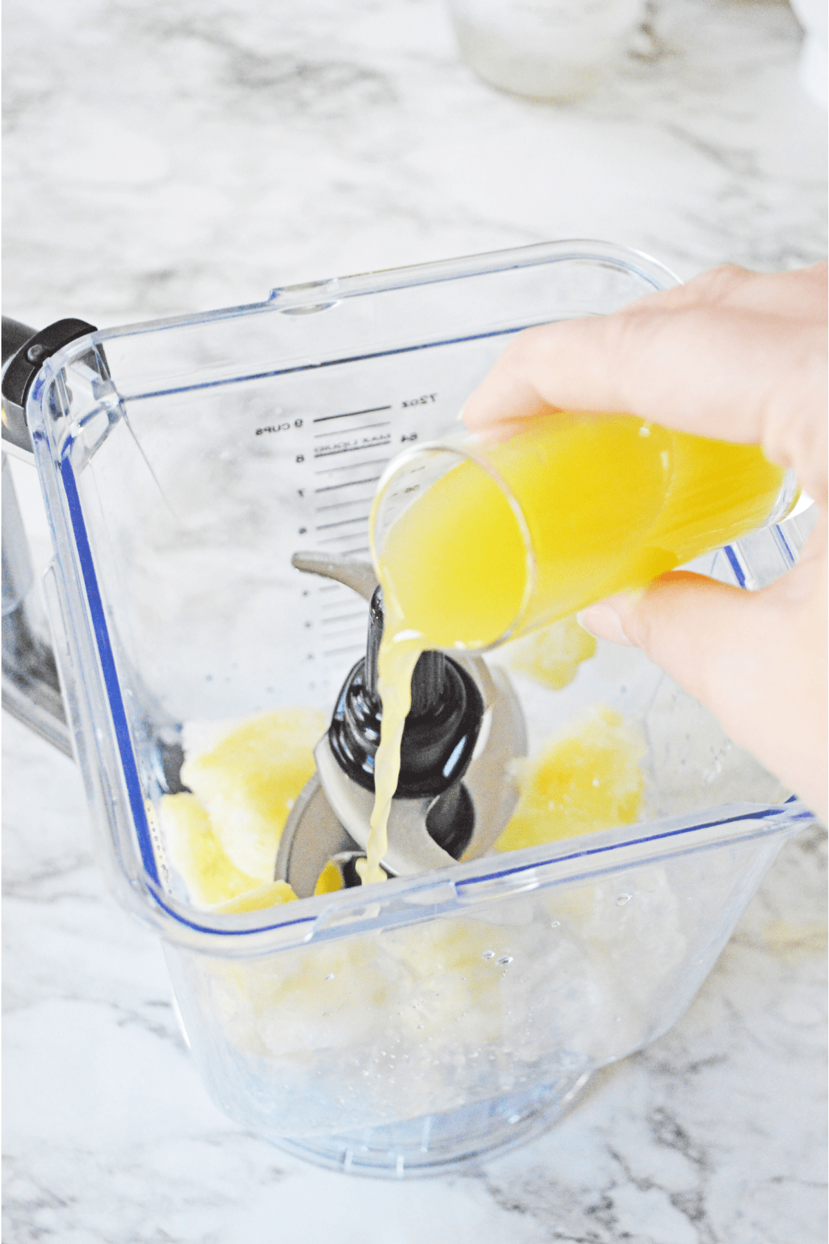 Pouring pineapple juice in blender