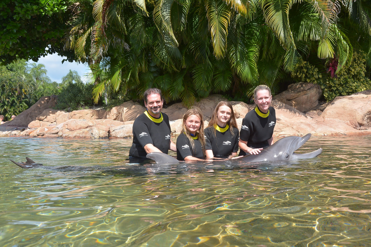 Family posing with dolphin