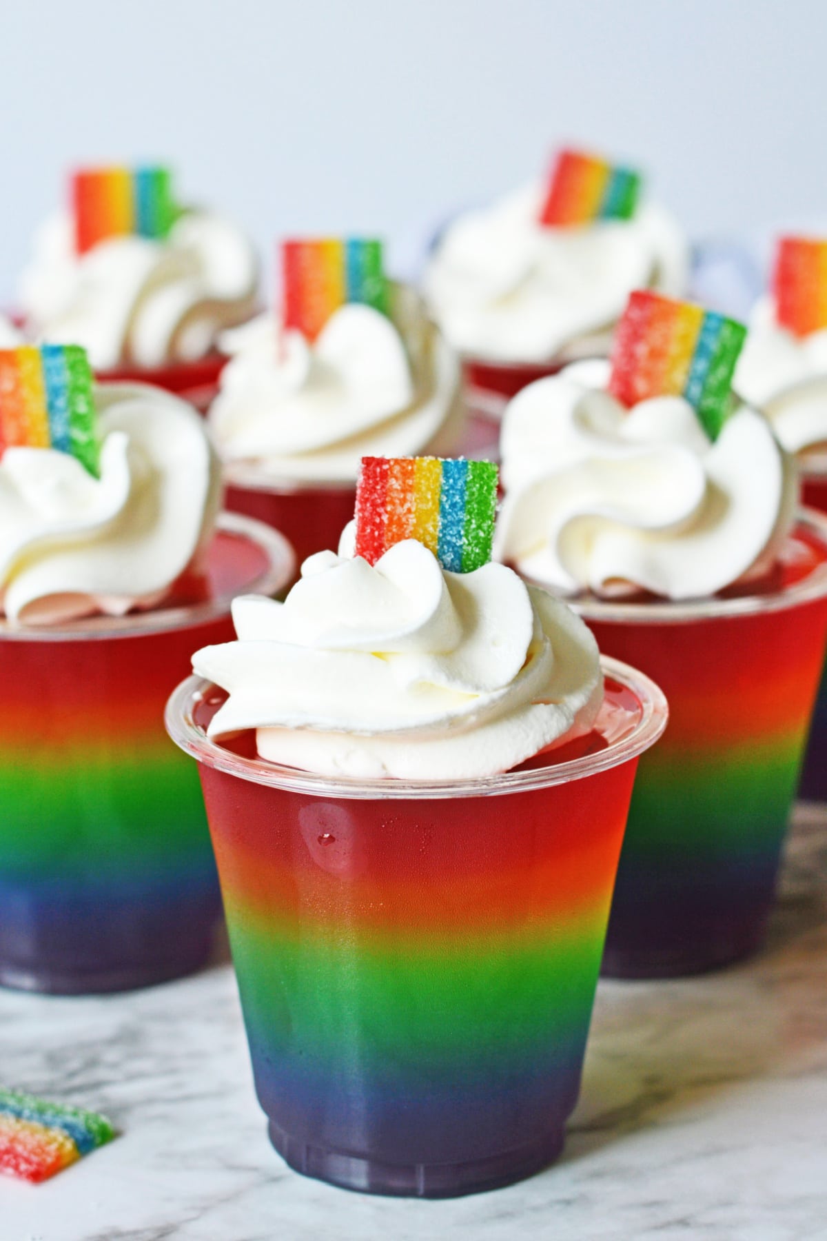 Rainbow jello shots with Cool Whip and rainbow candy