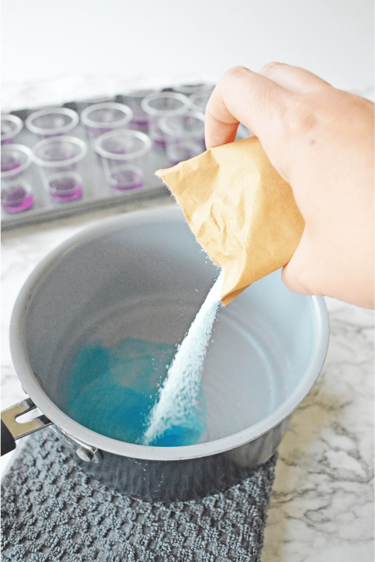 Pouring blue jello into hot water