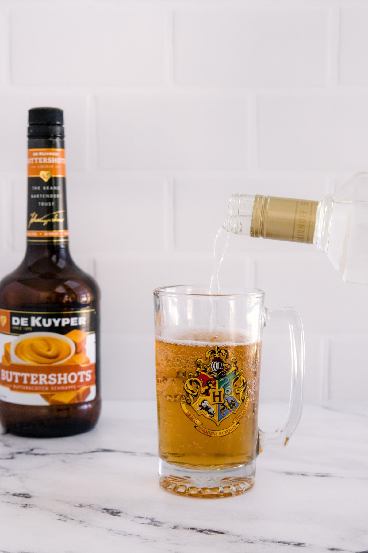 Pouring vanilla vodka for boozy butterbeer