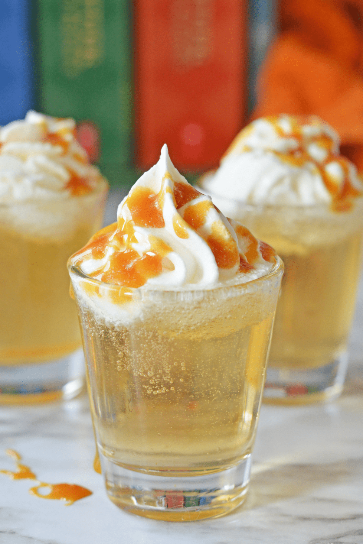 Butterbeer shots with whipped cream and butterscotch syrup