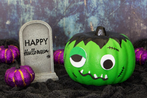Frankenstein pumpkin with tombstone and purple pumpkins