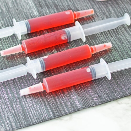 Syringe jello shots on gray placemat