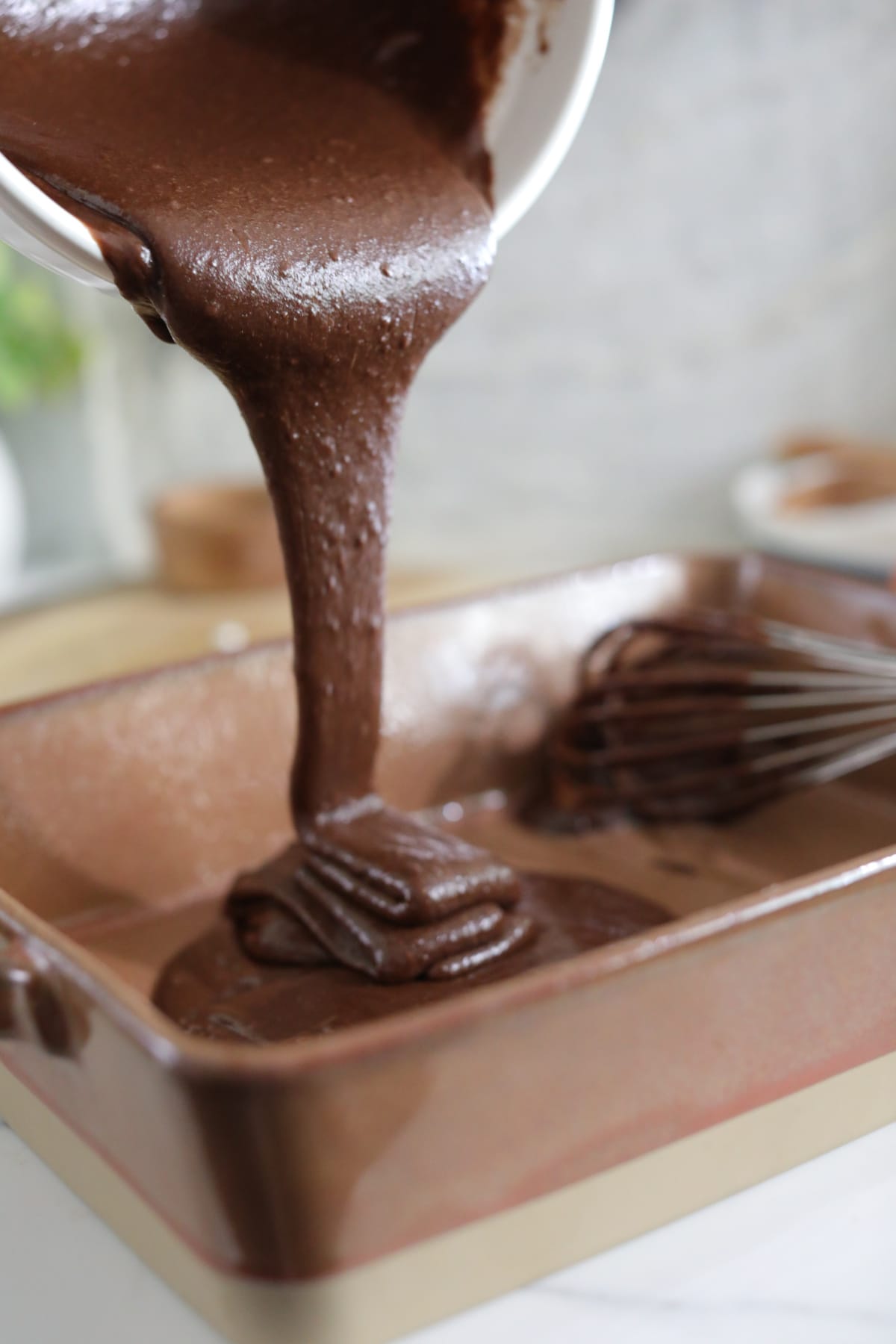 Pouring brownie batter into baking pan