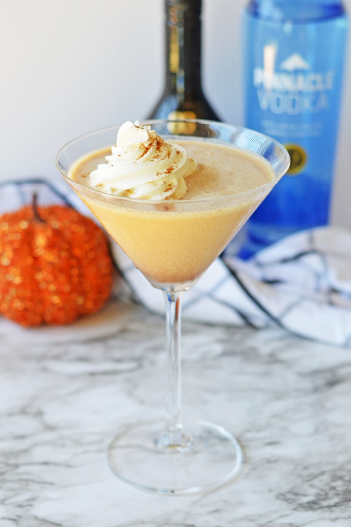 Pumpkin martini with alcohol in the background