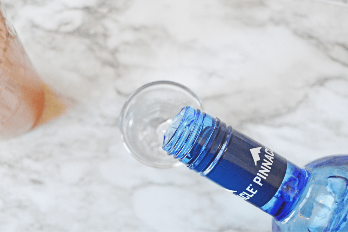 Pouring whipped cream vodka into shot glass