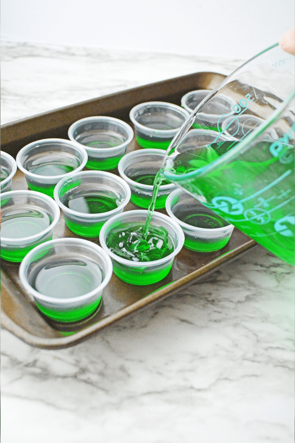 Pouring lime jello into shot cups