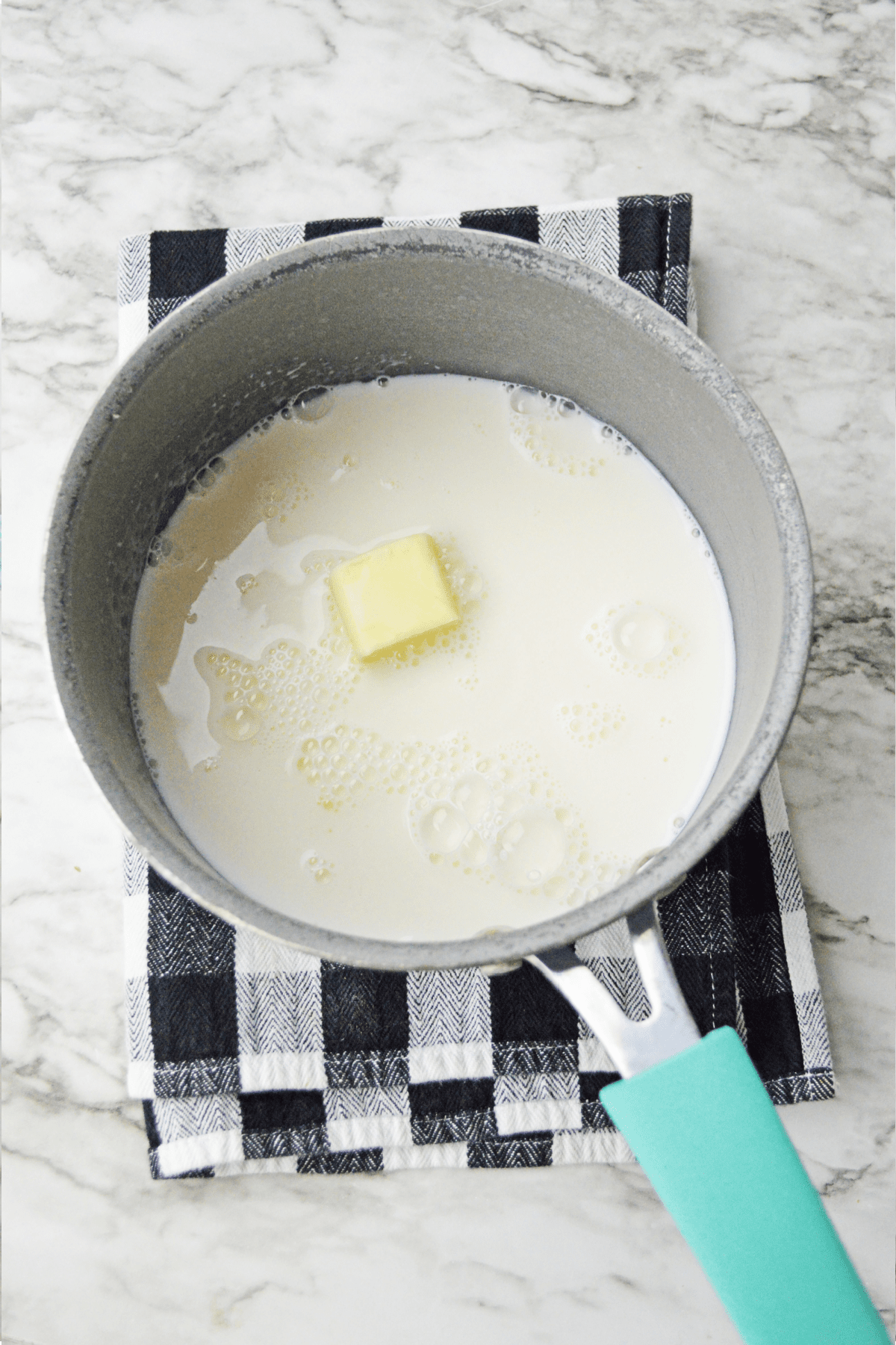 Butter and brown sugar with milk in saucepan