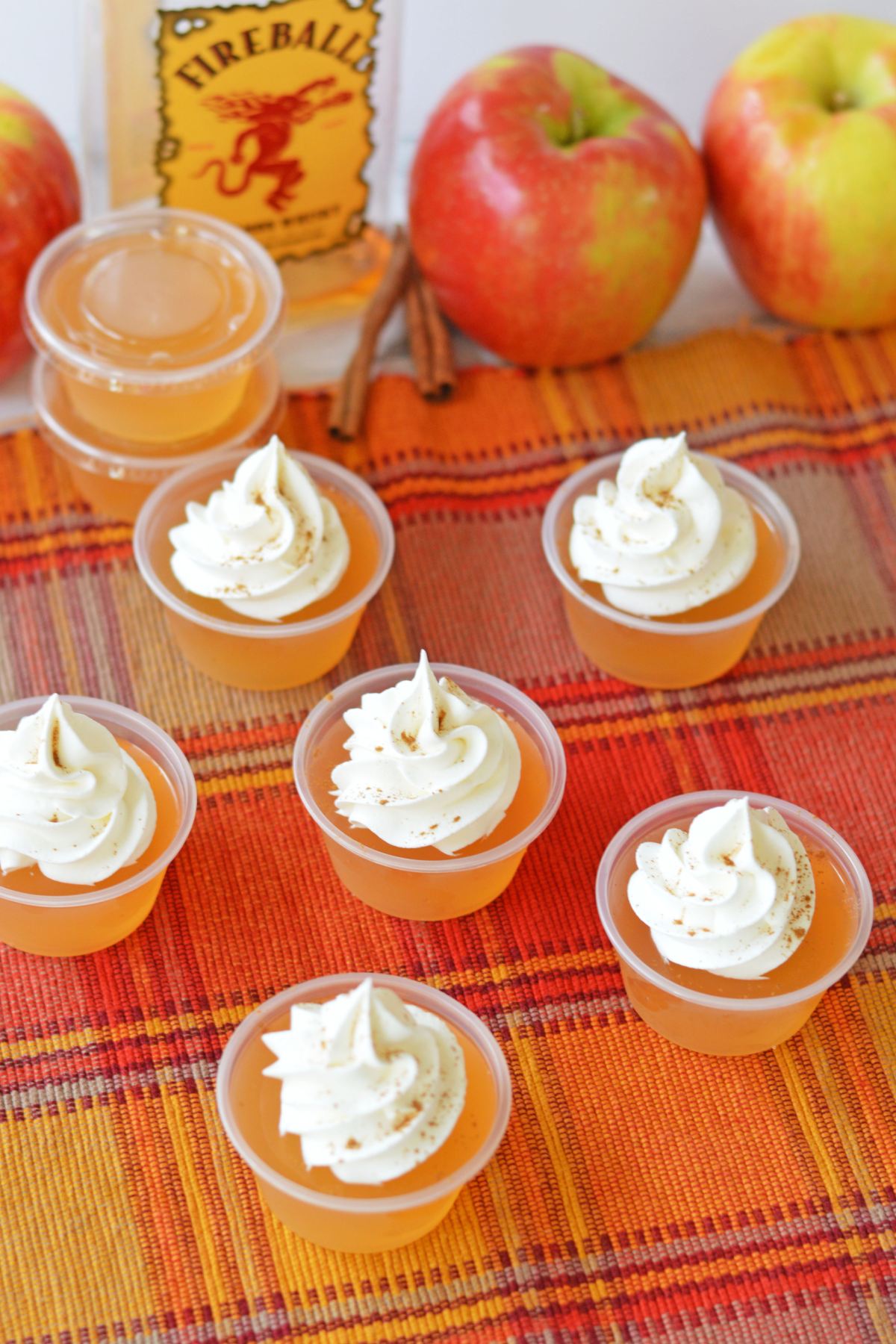 Fireball apple cider jello shots with bottle of whiskey and apples