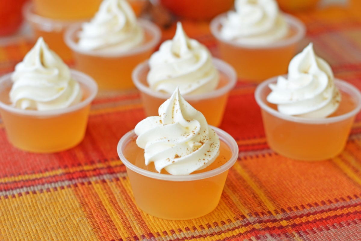Apple cider jello shots with whipped cream and cinnamon
