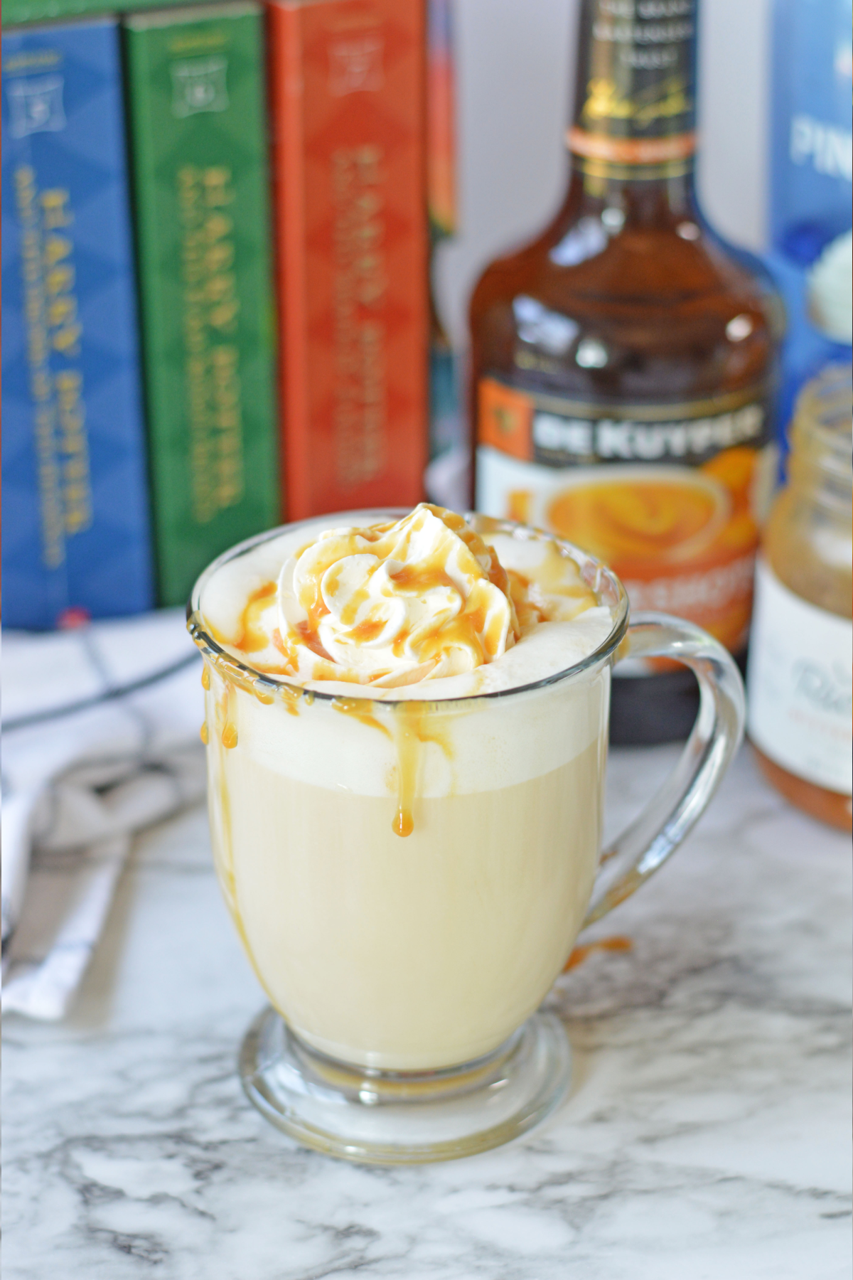 Hot boozy butterbeer with Harry Potter books and alcohol in background