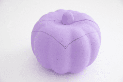 Purple pumpkin with shape of Dracula's hair drawn on it