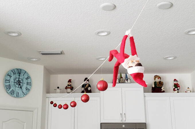 Elf hanging from string with ornaments