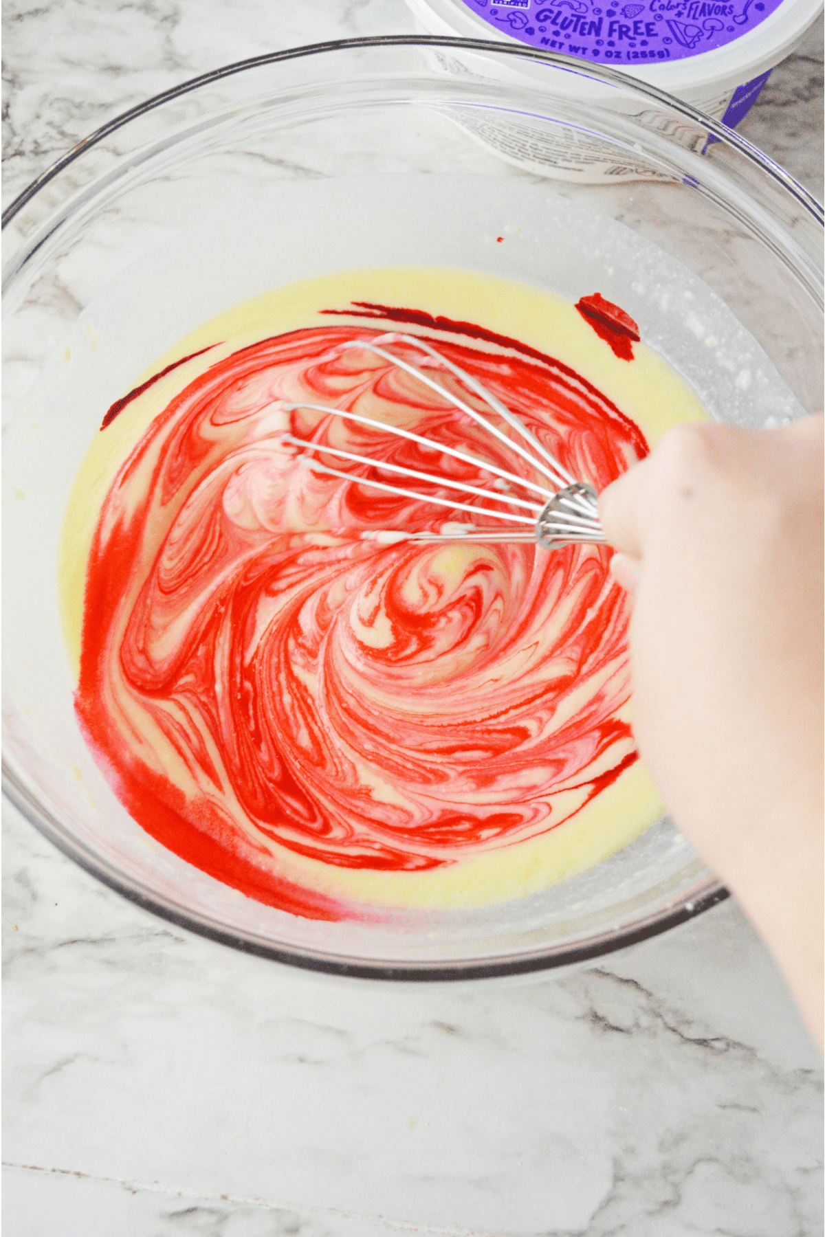 Red food coloring being mixed into pudding