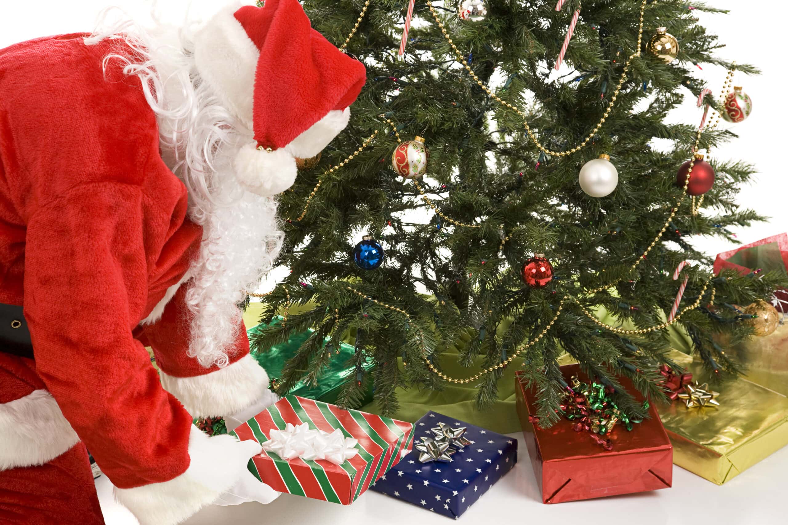 Santa putting gifts under tree