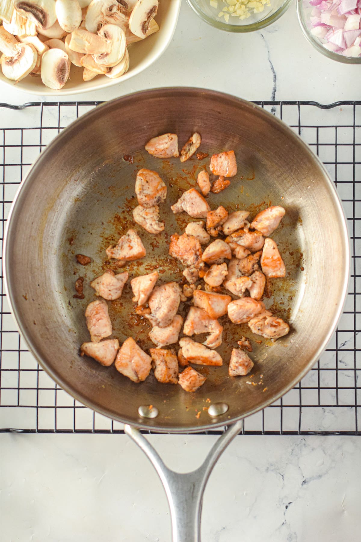 Chicken pieces cooking in pan