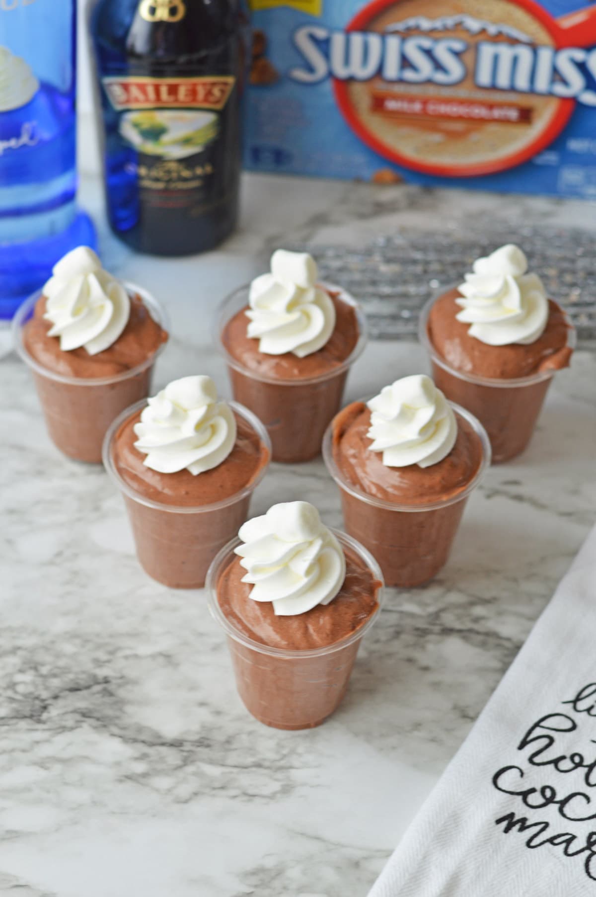 Chocolate pudding shots with ingredients in background