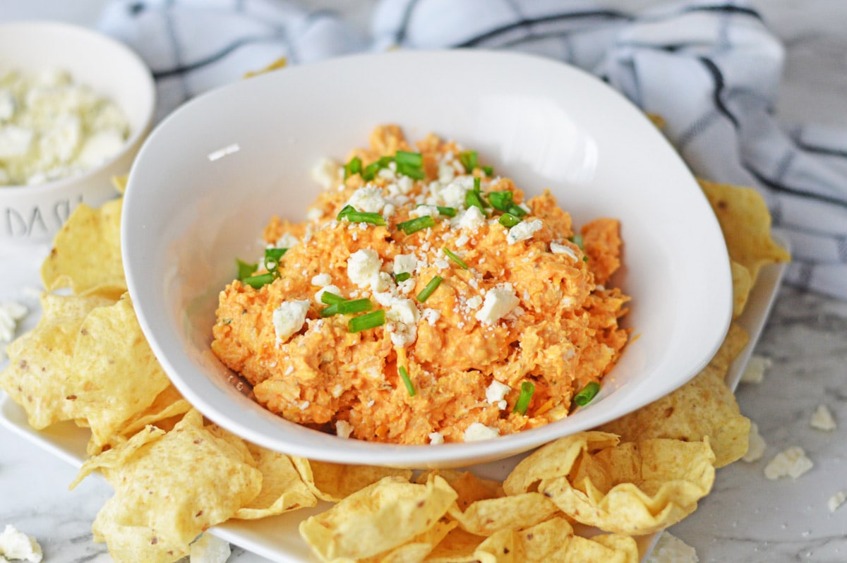 Buffalo chicken dip in bowl with black and white cloth in background