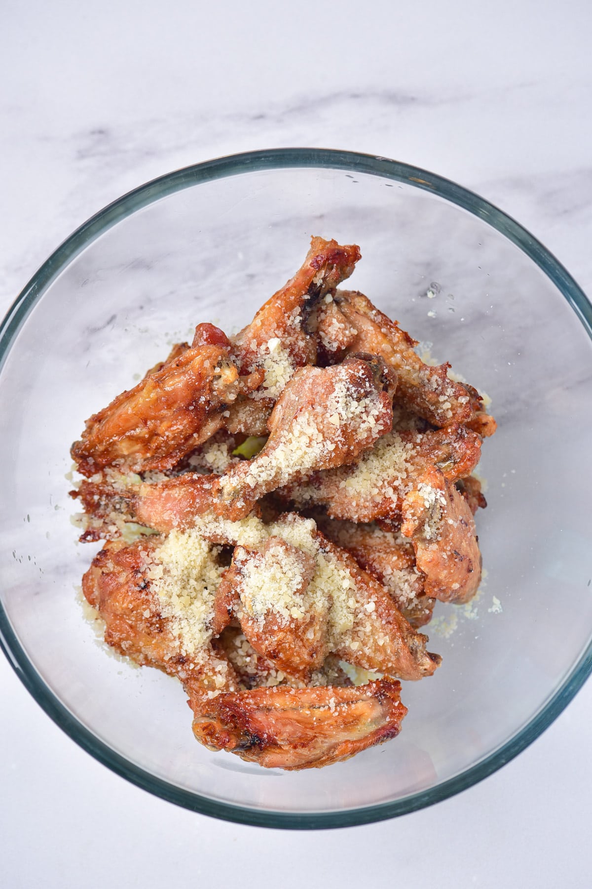 Chicken wings in bowl with butter and parmesan