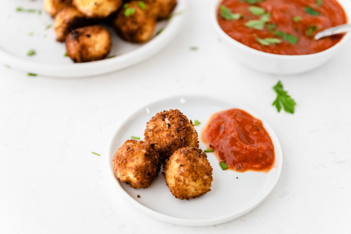 Goat cheese balls on plate with sauce