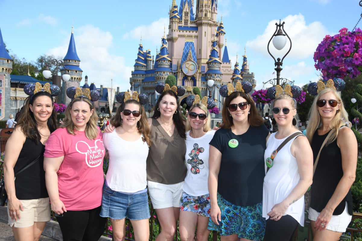 Group of friends posing for a photo in front of Cinderella's Castle