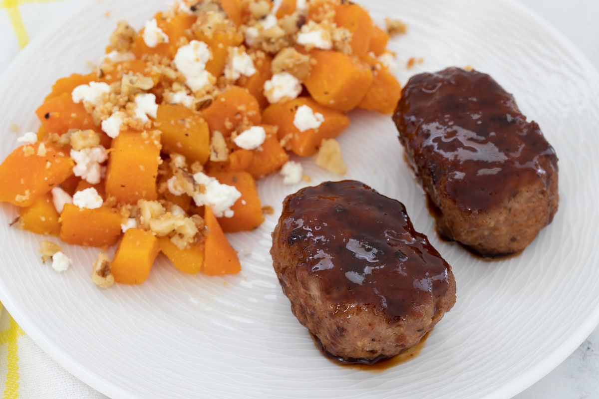 Mini meatloaves with butternut squash on white plate