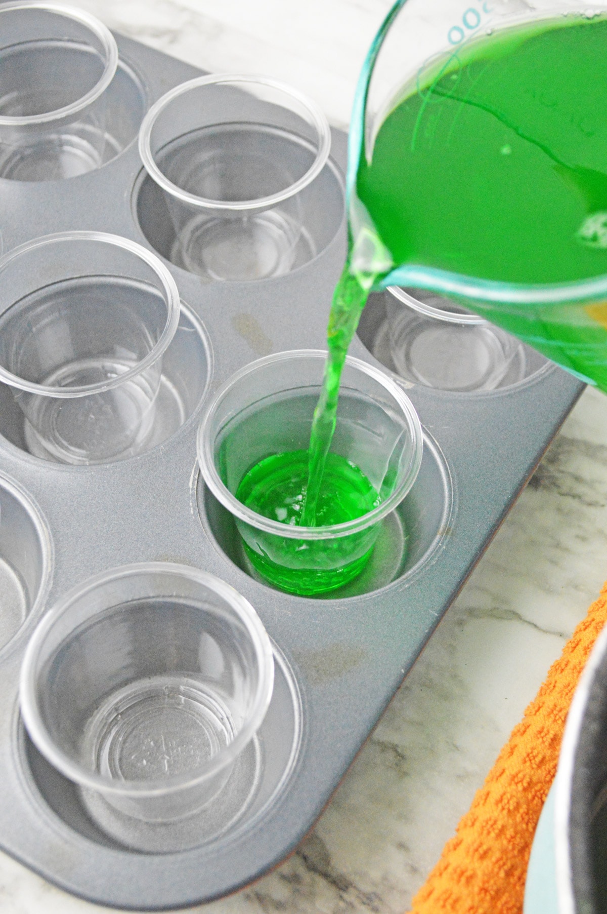 Pouring green jello into shot cups