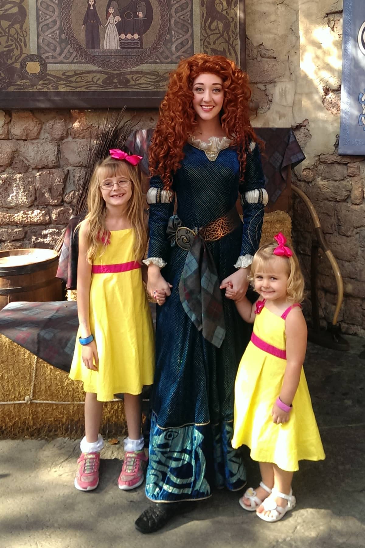 Two little girls taking a picture with Merida