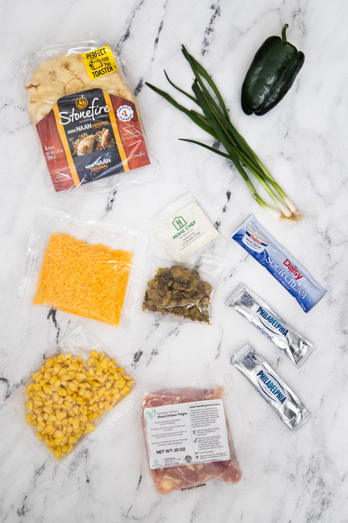 Ingredients for spicy chicken flatbread on marble counter