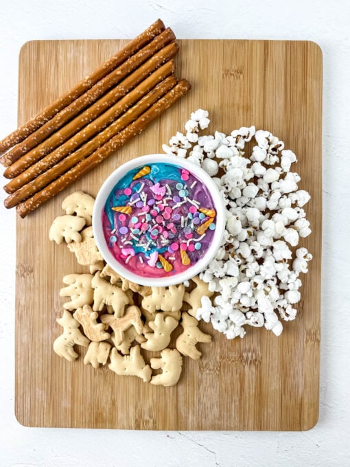 Charcuterie board with dip, pretzels, cookies and popcorn