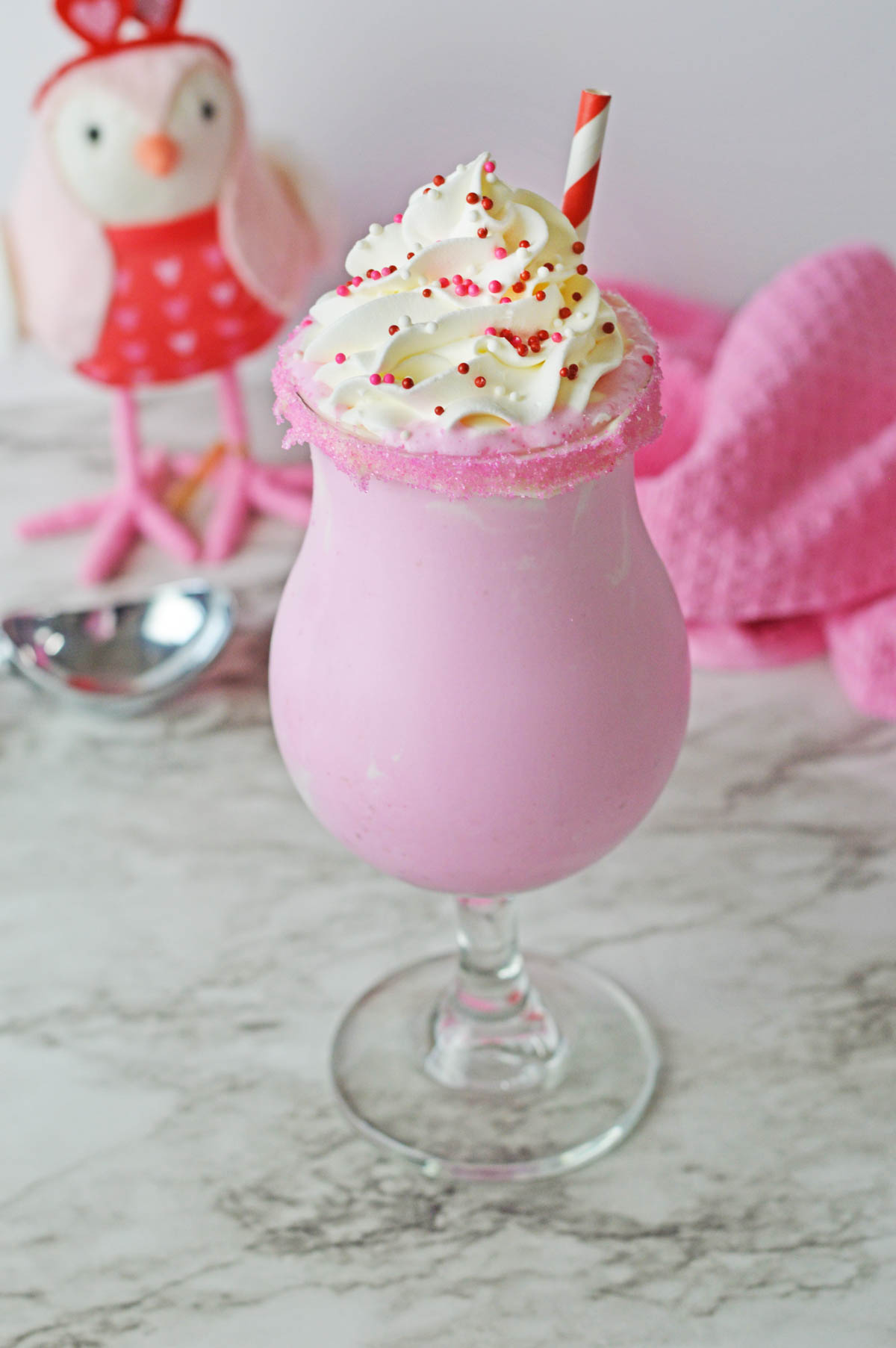Pink milkshake with whipped cream and sprinkles