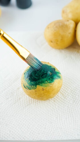 Painting food coloring over potato