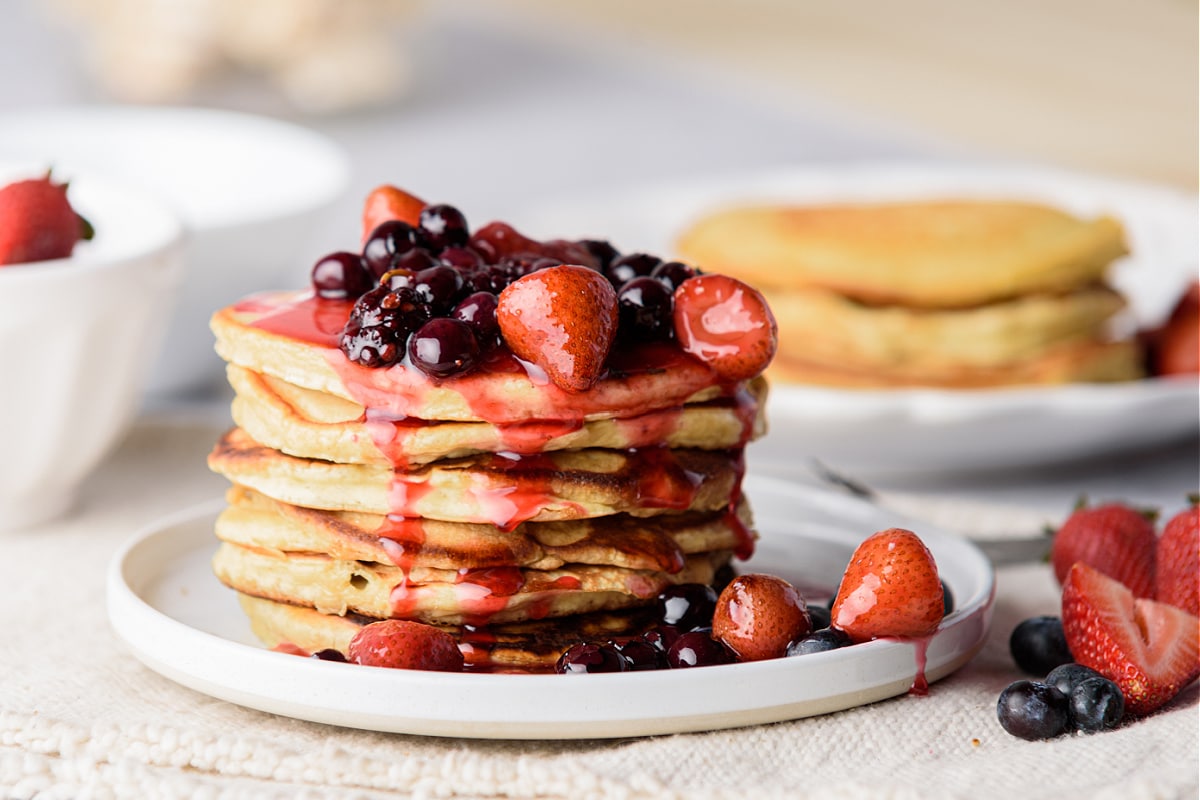 Pancakes with fruit syrup on white plate