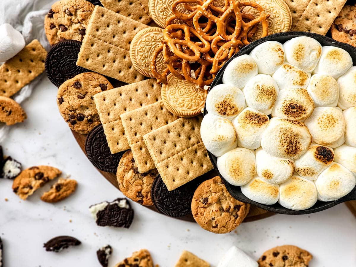 Smores dip with dipping snacks on cutting board