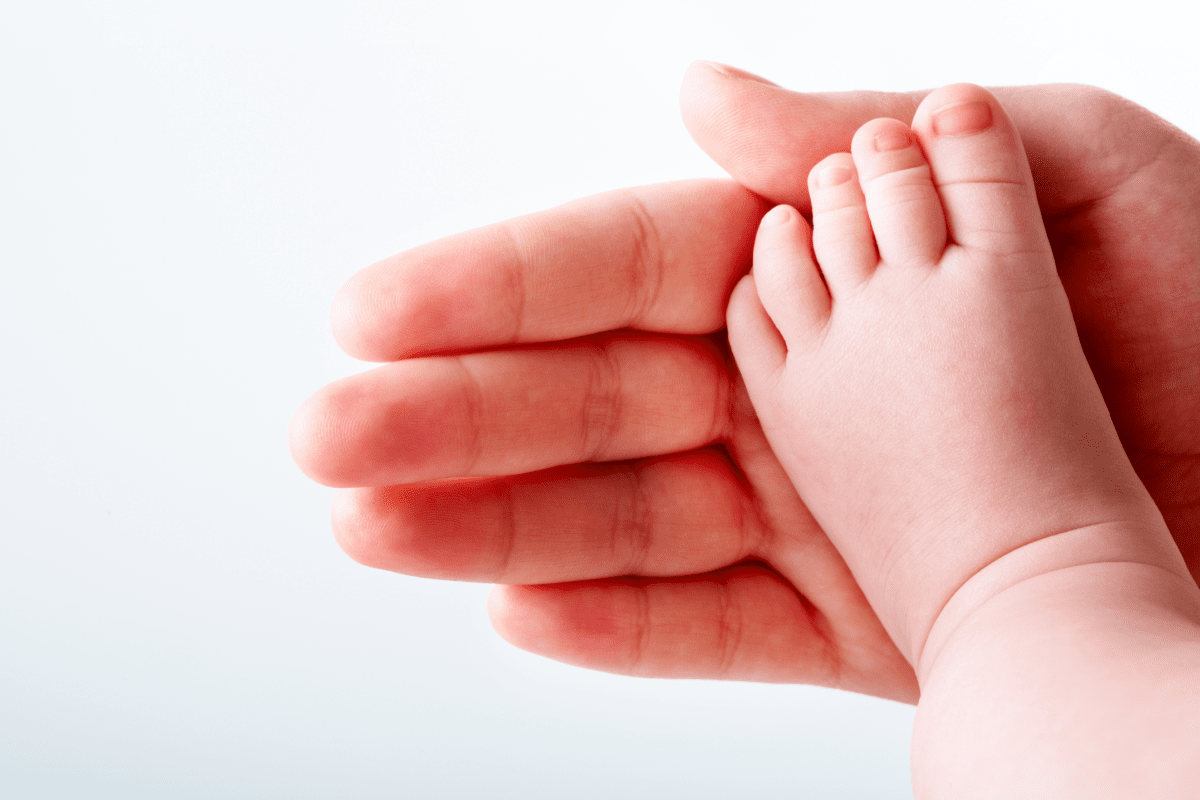 Baby foot with adult hand